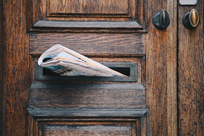 Close-up of newspaper in door