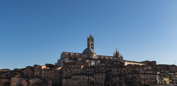 Low angle view of buildings against clear blue sky