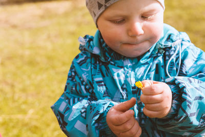 Close-up of cute boy holding petal