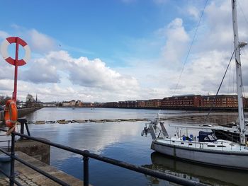 Commercial dock by river against sky