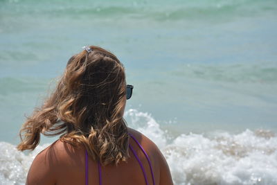 Rear view of woman standing against sea