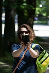 Woman taking selfie through mobile phone in forest
