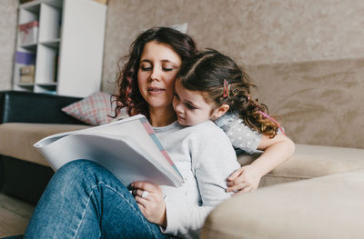 Happy woman sitting on sofa at home