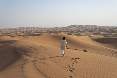 Rear view of man on sand dune