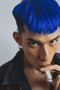 Close-up portrait of young man holding cigarettes