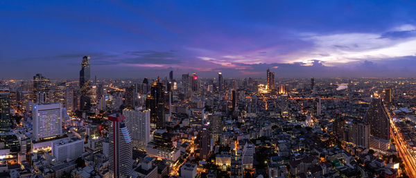 High angle view of illuminated city buildings against sky