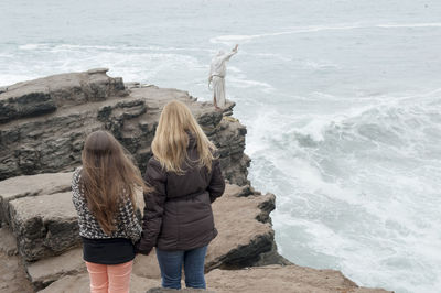 Rear view of women standing on beach