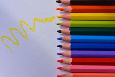 High angle view of multi colored pencils against white background