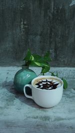 Close-up of coffee cup on table against wall