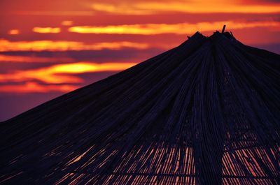 Low angle view of silhouette roof against sky during sunset