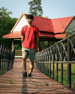 Full length portrait of man standing on footbridge