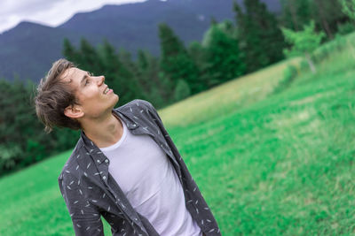 Young man standing on grassy field