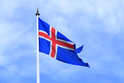 Low angle view of flag against blue sky