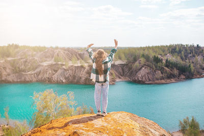 Rear view of woman standing by lake