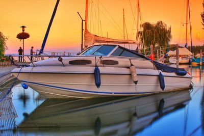 Yacht moored at harbor during sunset