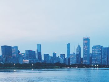 Sea by buildings against sky in city