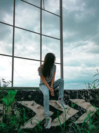 Woman looking at camera against sky