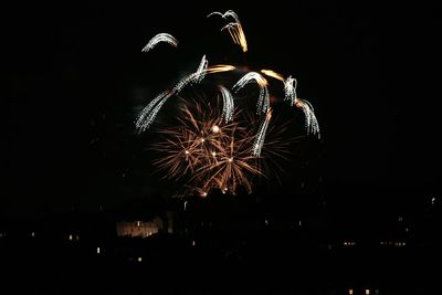 Low angle view of firework display at night