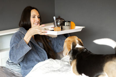 Young woman with dog sitting at home