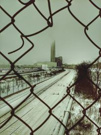 Railroad tracks seen through chainlink fence