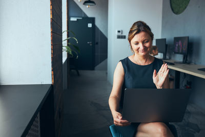 Woman having business video call on laptop in office. mature busy woman remotely working from office