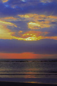 Scenic view of sea against dramatic sky during sunset