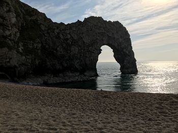 Rock formation in sea against sky