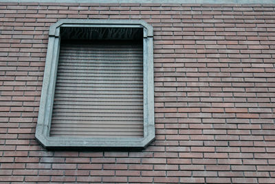 Low angle view of window on brick wall of building