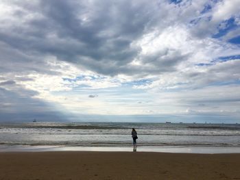 Scenic view of beach against cloudy sky