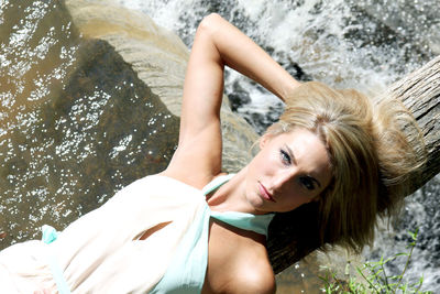 High angle portrait of woman lying on waterfall