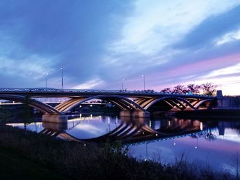 Bridge over river against cloudy sky