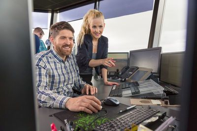 Female dispatcher helping colleague in office