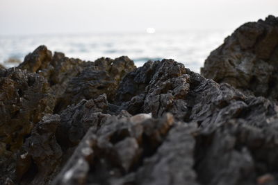 Rocks on sea shore against sky