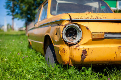 Old yellow wrecked car in vintage style. abandoned rusty yellow car. 