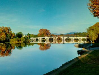 Bridge over river against clear blue sky