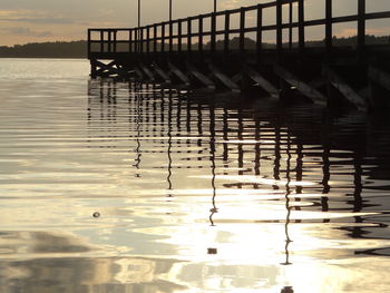 Silhouette pier on lake against sky during sunset