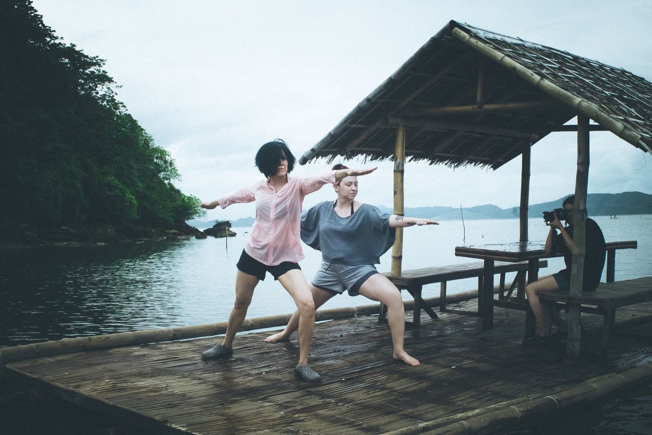 full length, water, lifestyles, lake, leisure activity, tree, casual clothing, togetherness, vacations, sky, in front of, person, summer, nature, day, tranquil scene, outdoors, beauty in nature, tranquility