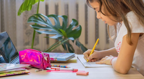 Midsection of woman drawing on book at office