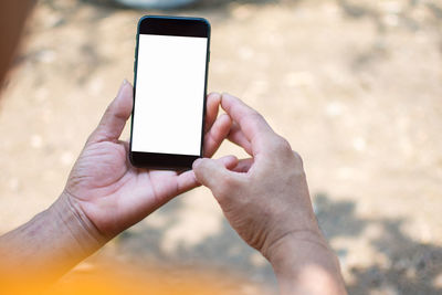 Close-up of cropped hands holding smart phone