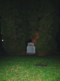 Built structure on field against trees at night