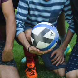 Midsection of man playing soccer ball