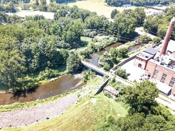 High angle view of trees by river against buildings