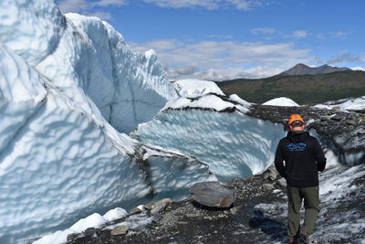 Full length of man standing on rock in snow