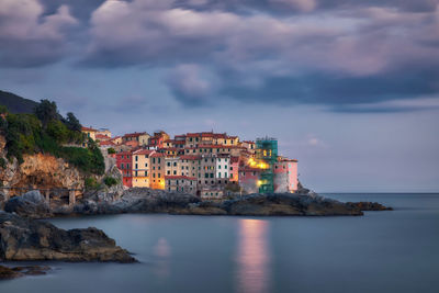 Tellaro by sea against sky at dusk