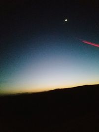 Silhouette landscape against sky at night