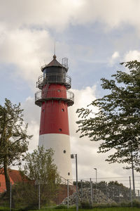 Lighthouse by sea against sky