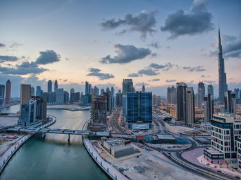 Aerial view of buildings against cloudy sky