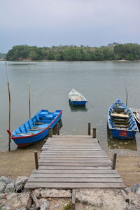 Boats moored on sea against sky