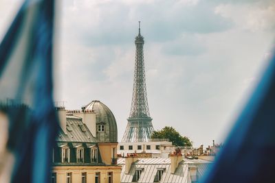 Buildings in city against cloudy sky