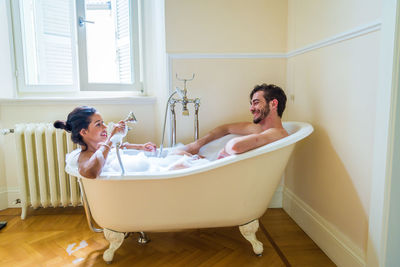 Young couple sitting in bathroom